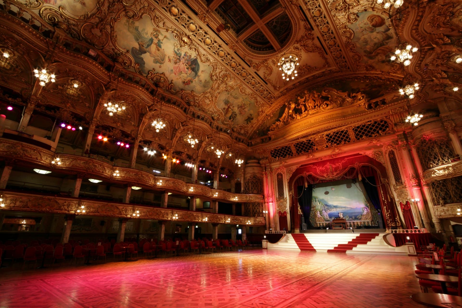 Ornate ballroom with stage and tiered seating for luxury event draping in Montreal